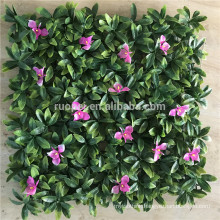 Beautiful artificial vertical green wall with pink flower